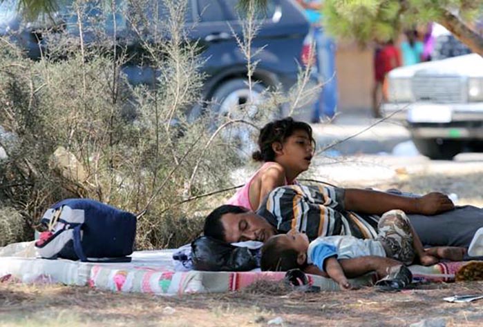 A family from the camp, displaced from the fighting, rests during a moment of calm.
