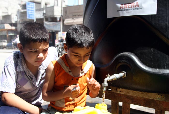 Boys fill up water jugs in Khan Younis, where Anera set up and continually refills 20 communal water tanks, each with a capacity of 2,400 liters (634 gallons).