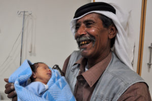 Proud Palestinian grandfather holds his grandson for the first time in Al-Rashaydeh village in the West Bank.