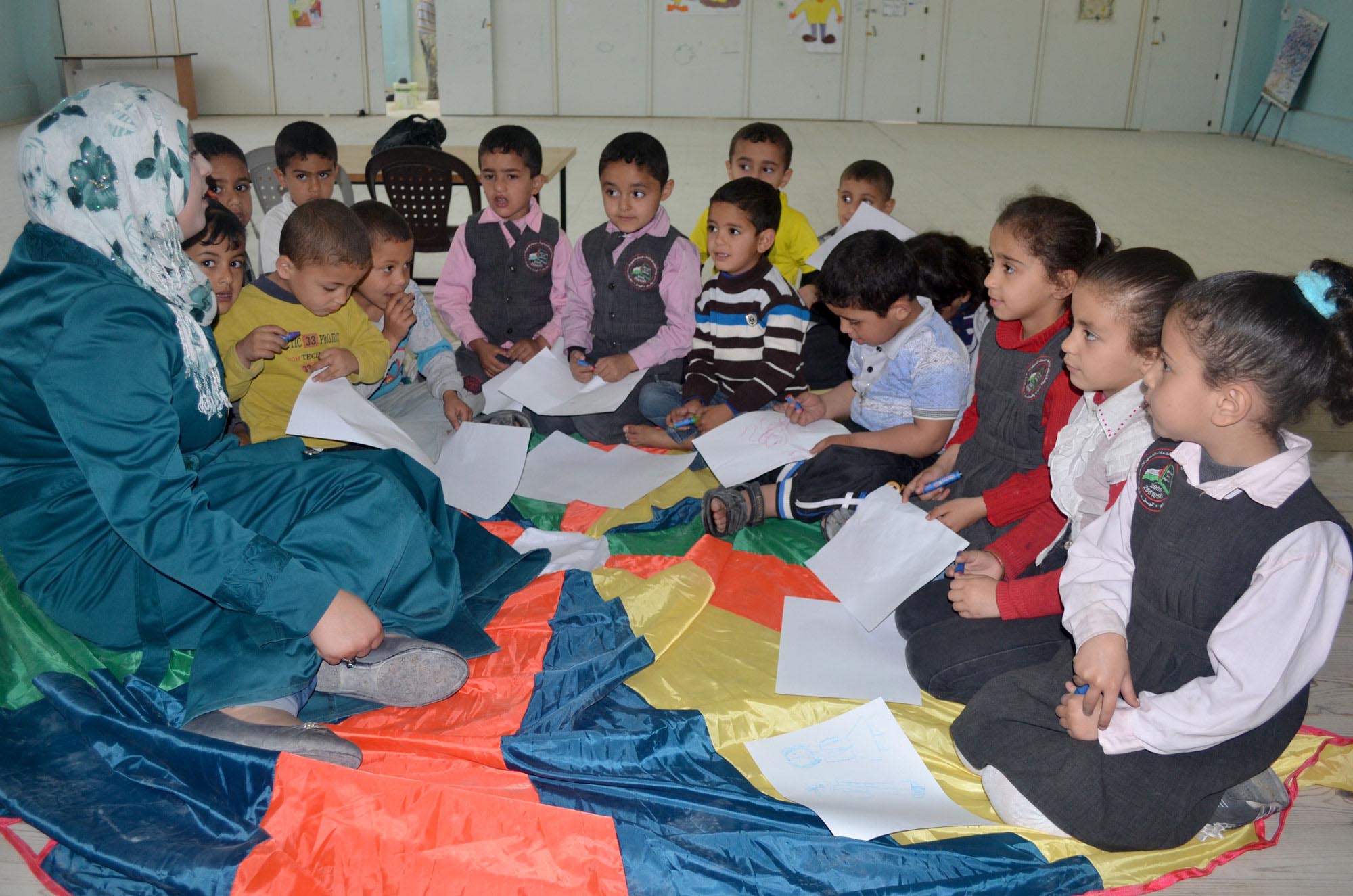 Gaza preschool teacher learned to use a colorful parachute to liven up a reading session.