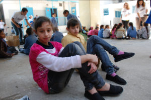 Two Palestinian girls receive a new pair of shoes one of Lebanon's refugee camps where their families sought shelter from Syria's conflict.