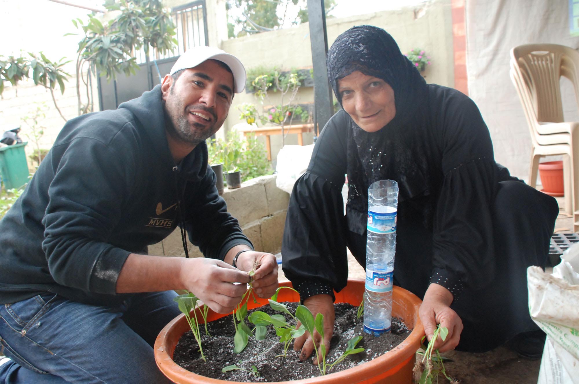 Participants in Anera's rooftop gardening workshop learn to use old plastic bottles and other recycled items to plant and water a variety of vegetables and small fruit trees.