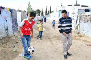 Abdel Hakim dribbles his soccer ball through the camp where he lives in Lebanon.