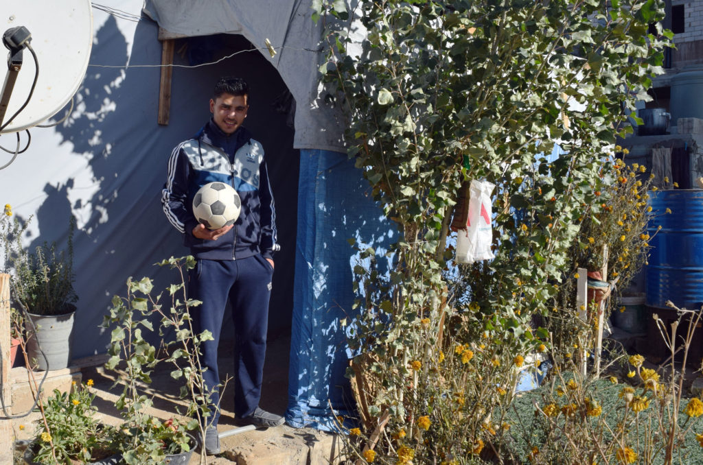 Anas, chosen for The Victorious, stands in front of his tent home.