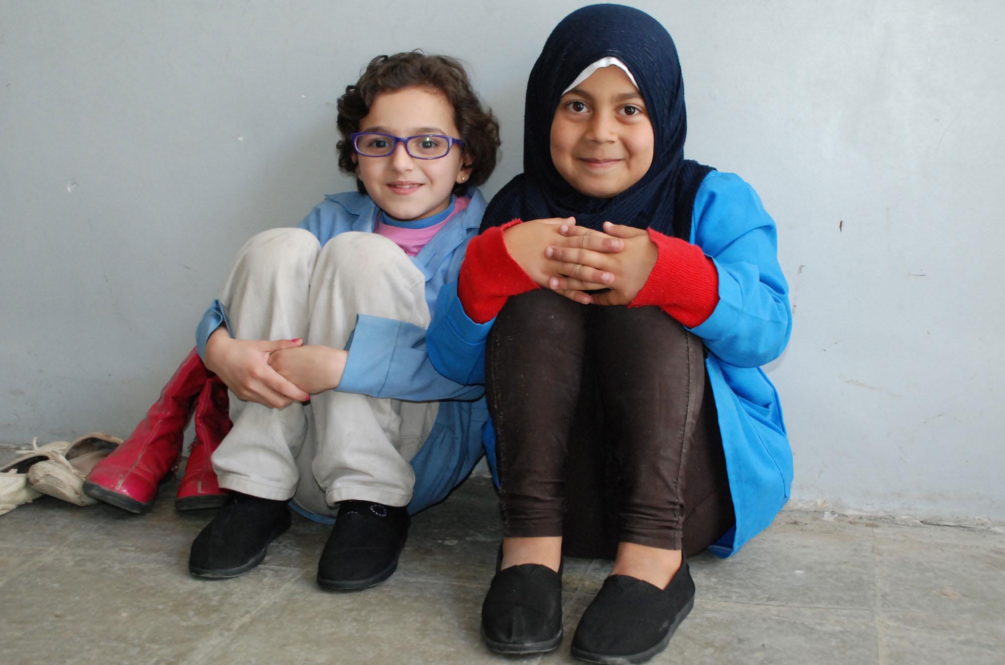 Two young Palestinian girls in one of Lebanon’s refugee camps wearing their new TOMS shoes.