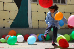 Palestinian children in Lebanon's refugee camps celebrate their new TOMS shoes that Anera has delivered to UNRWA schools.