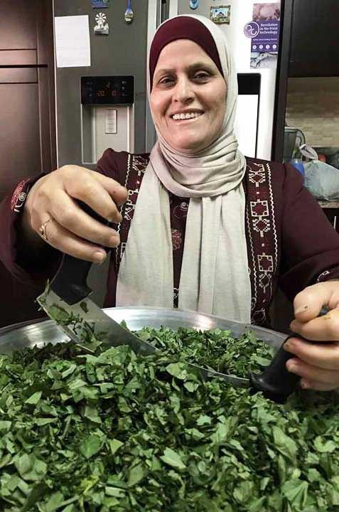 Nimeh chops molokhia in her West Bank kitchen.