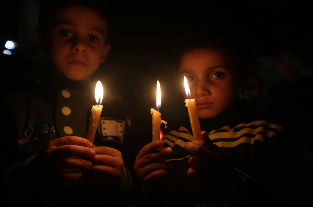 Children by candlelight during Gaza electricity crisis