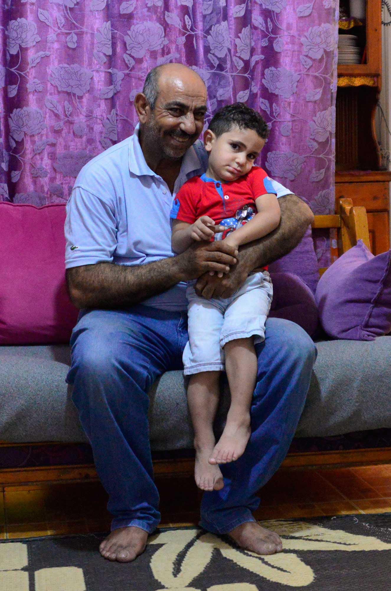 Mohammad holds his son, who has special needs, in Nahr El Bared refugee camp in Lebanon.