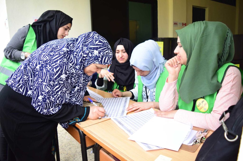 Volunteers sign community members up for an environmental project in Nahr El Bared, Lebanon.