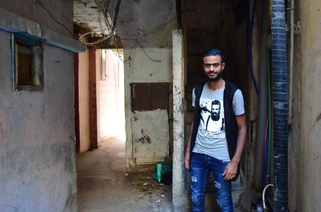 Omar, now a dabke teacher, stands outside his home in Ein El Hilweh camp.