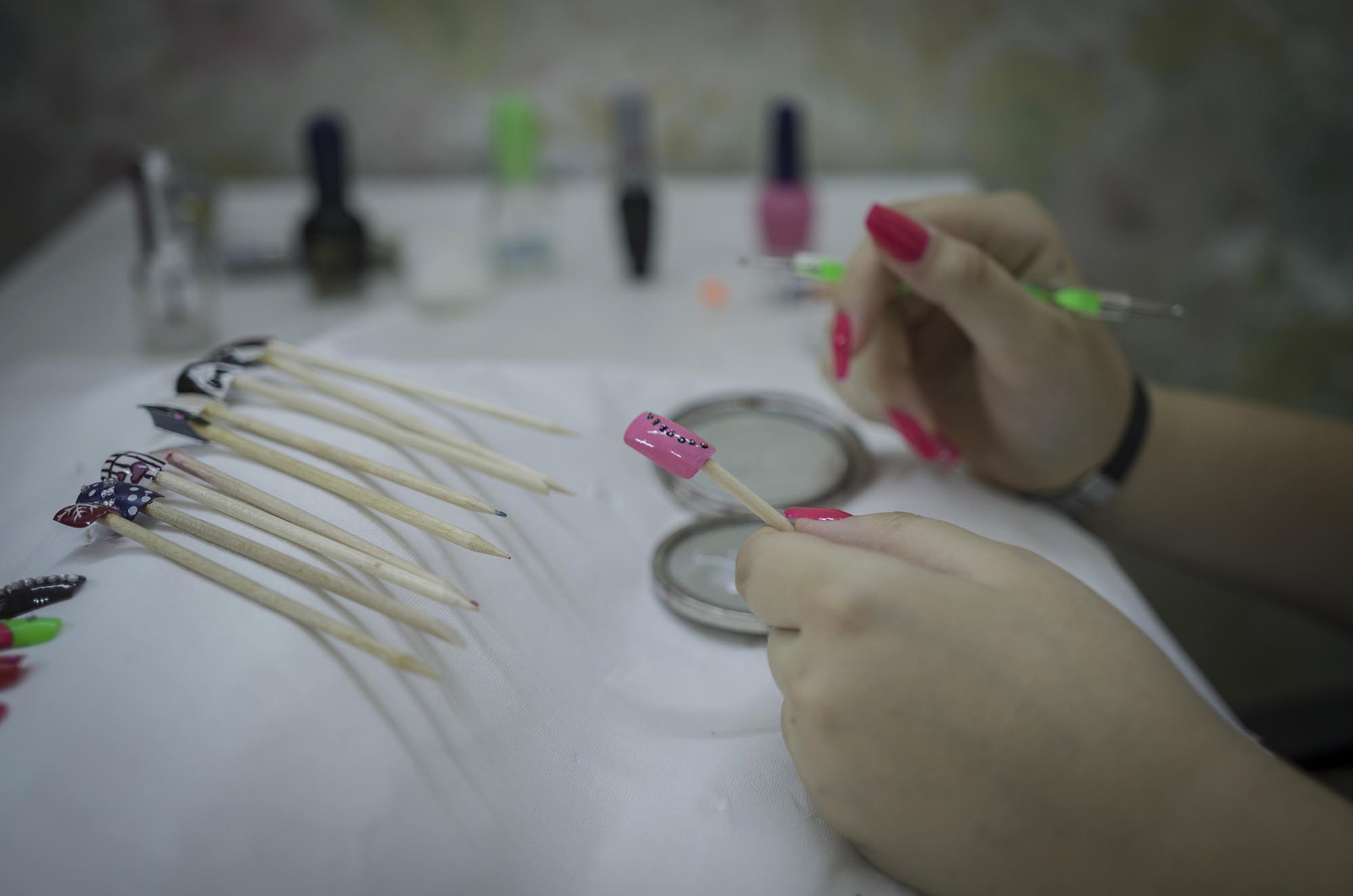 A girl paints false fingernails as part of Anera's makeup and hairdressing courses in Lebanon.