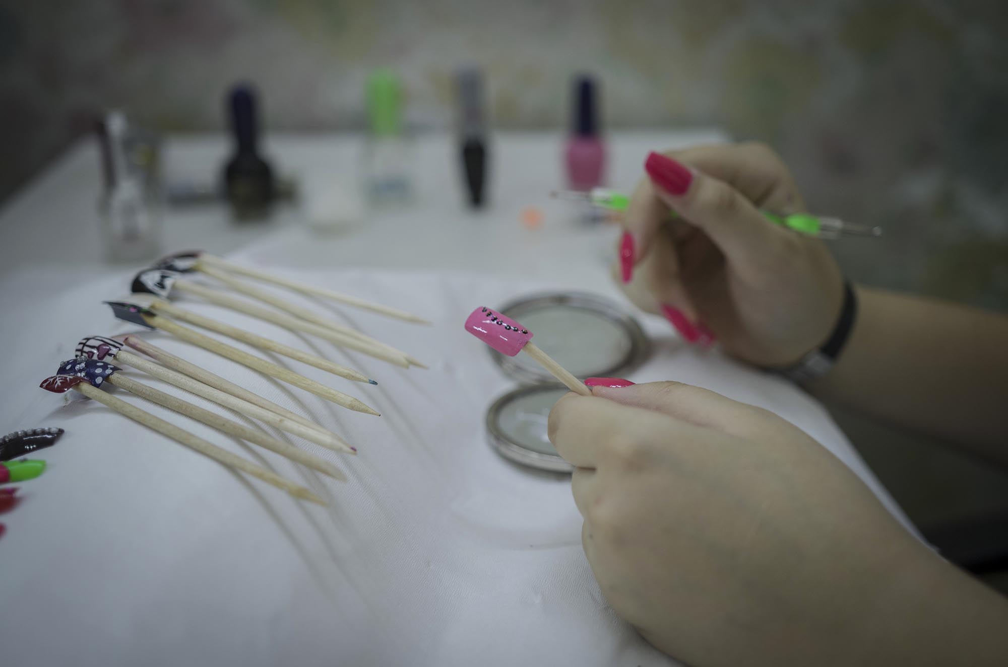 11_NailsCare_HarbAcademy_16817-EDIT A girl paints false fingernails as part of Anera's makeup and hairdressing courses in Lebanon.