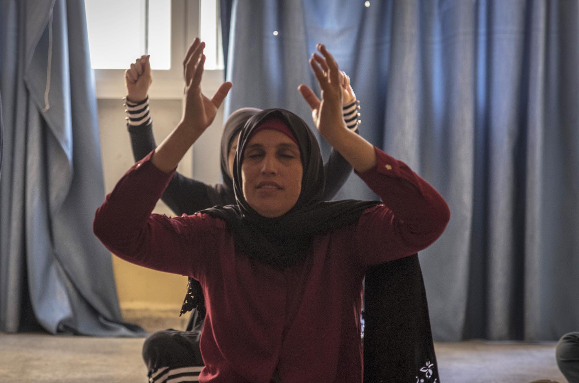 A young refugee woman takes yoga class in Lebanon.