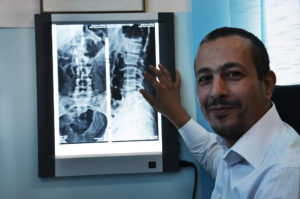 Dr. Wael Al-Rajabi checks an X-ray picture of a patient who suffers from back pain. in Hebron, Palestine