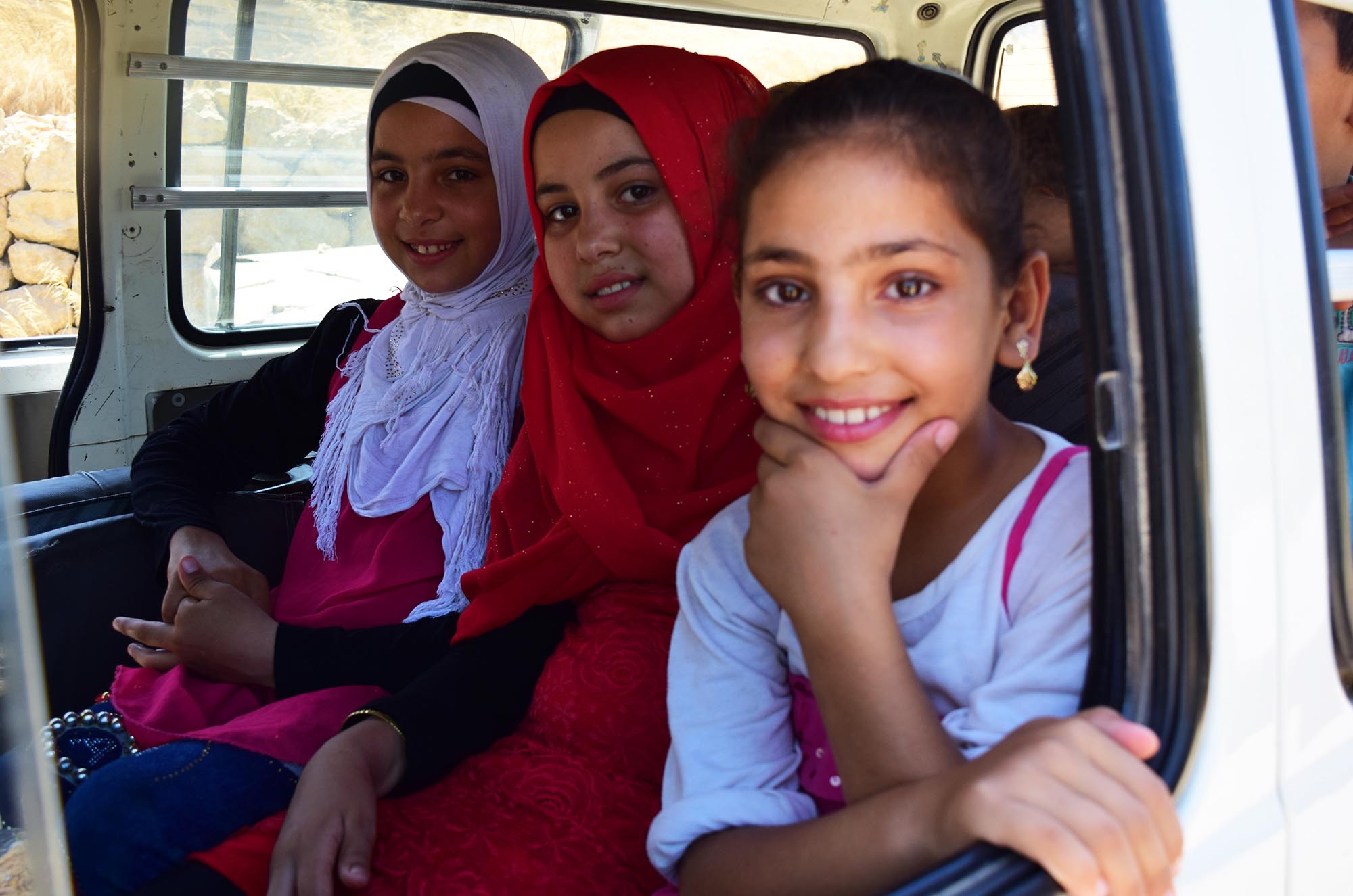 Dalaa, Shahed, and other Syrian refugee children from their camp take a bus heading to the local health center where they will receive free dental care.