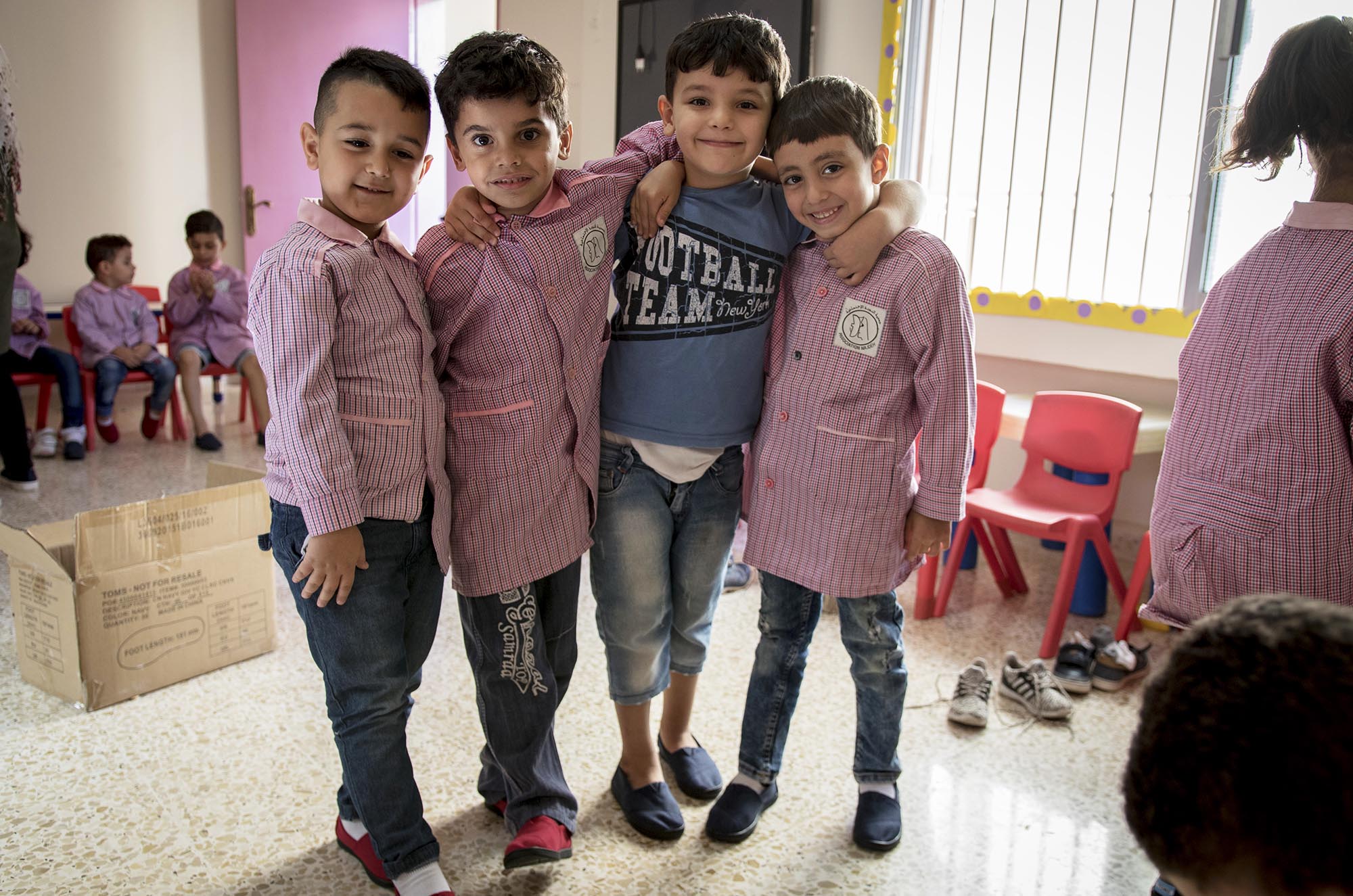 Preschoolers in Beddawi Camp in Lebanon picks up brand new TOMS shoes.