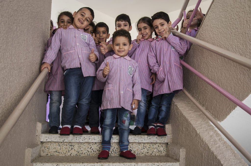 Preschoolers in Beddawi Camp in Lebanon picks up brand new TOMS shoes.