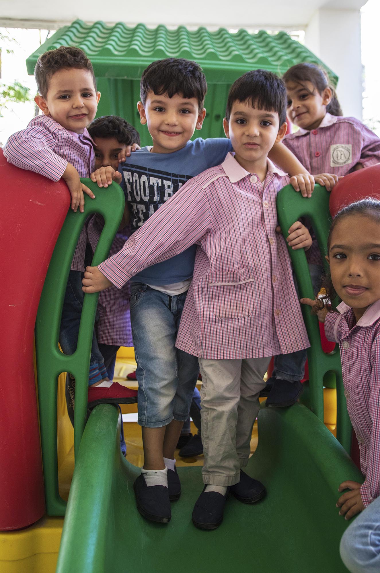 Preschoolers in the playground of Beddawi Camp in Lebanon picks up brand new TOMS shoes.