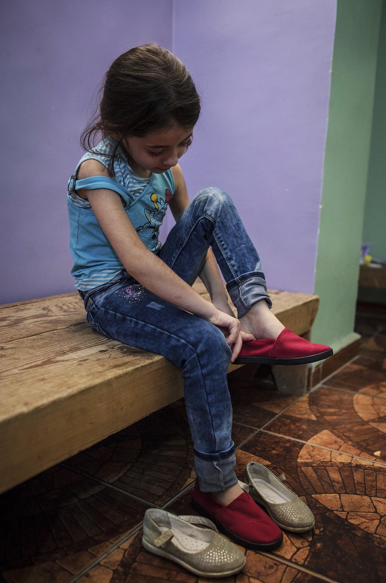 Preschoolers in Beddawi Camp in Lebanon picks up brand new TOMS shoes.