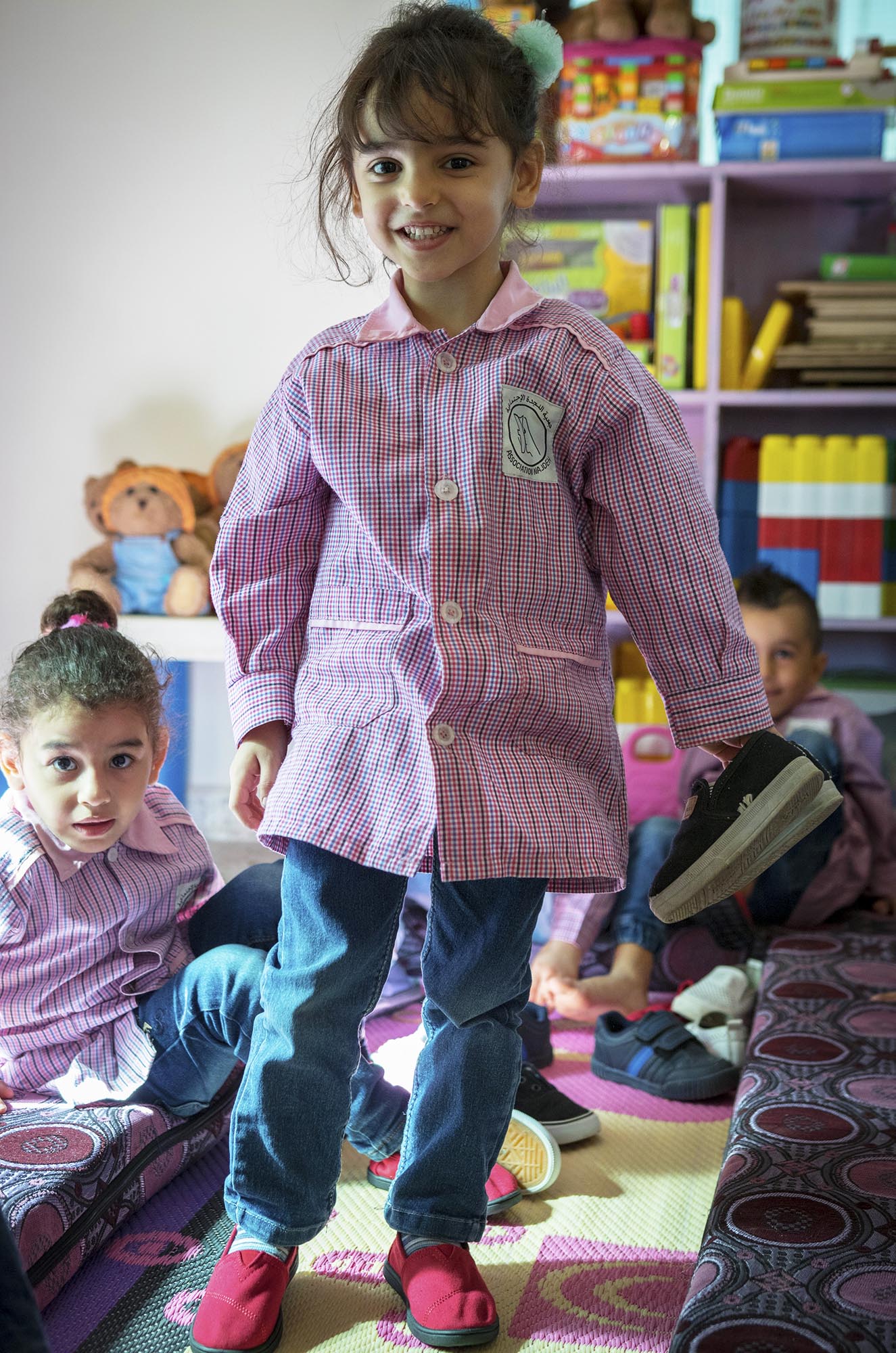 Preschoolers in Beddawi Camp in Lebanon picks up brand new TOMS shoes.