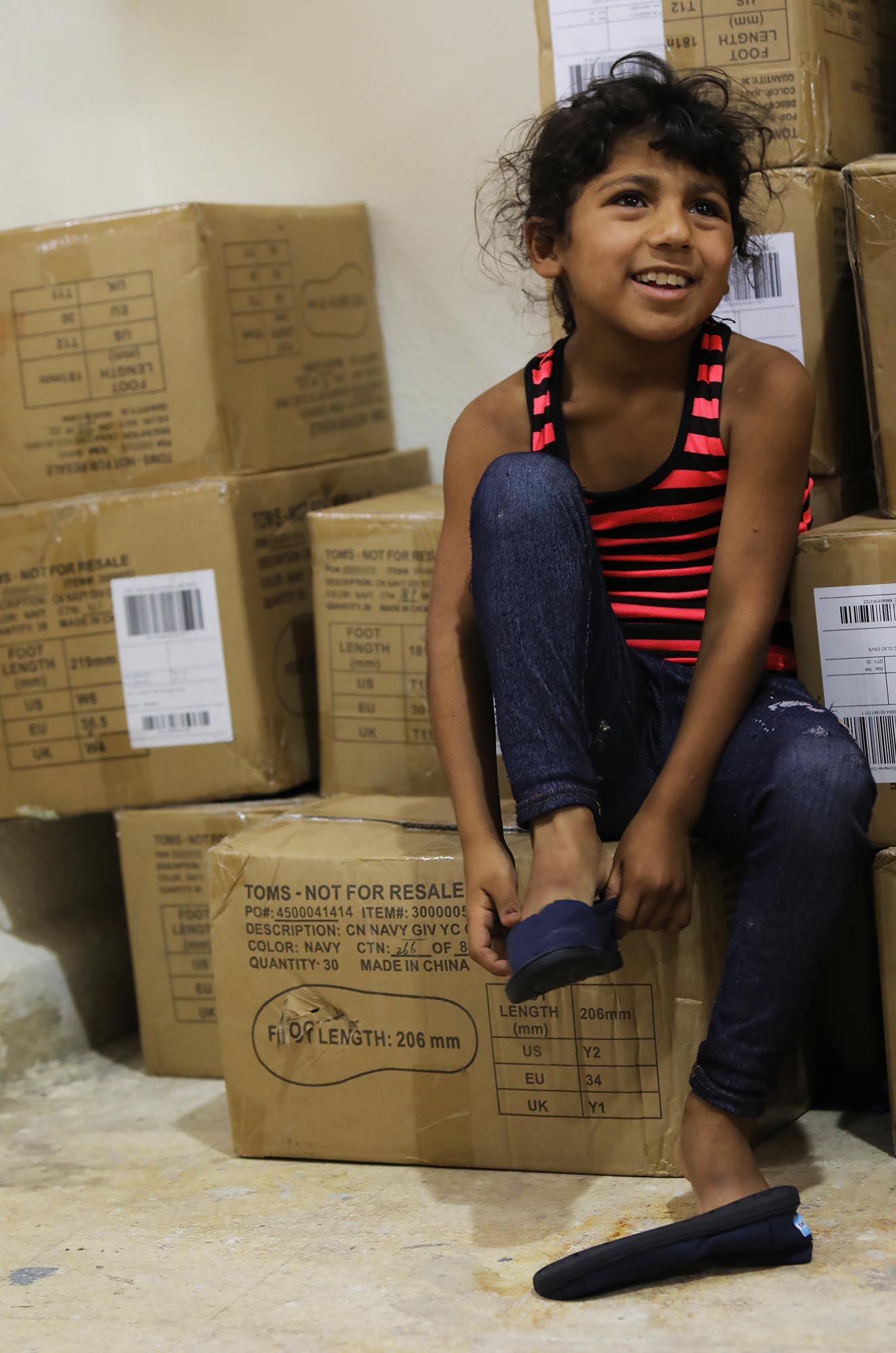 A girl puts on her brand new TOMS shoes in Lebanon.