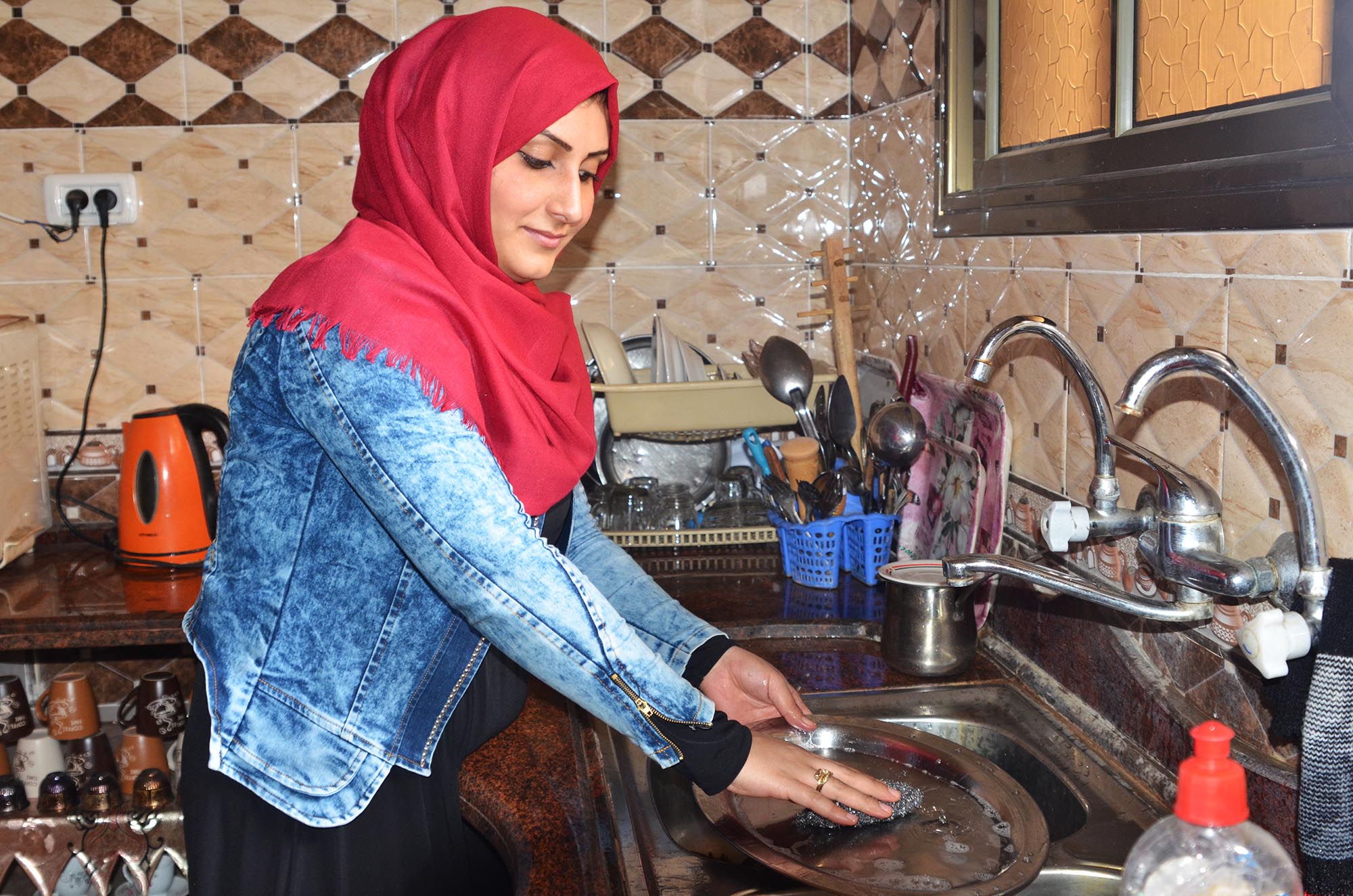 A Palestinian woman uses tap water from the rehabilitated water well in Beit Hanoun