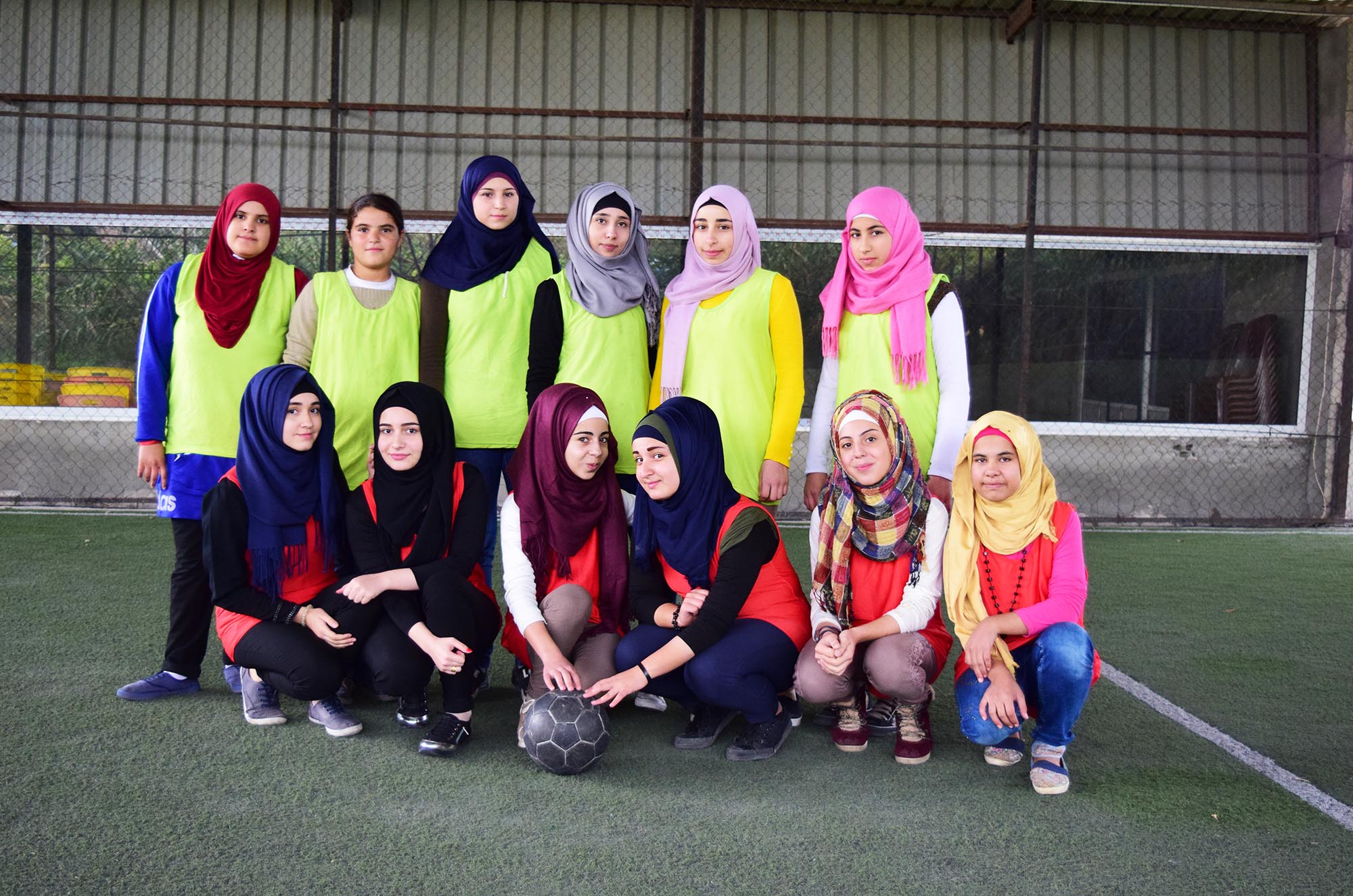 Girls on the football team association posing for a group photo.