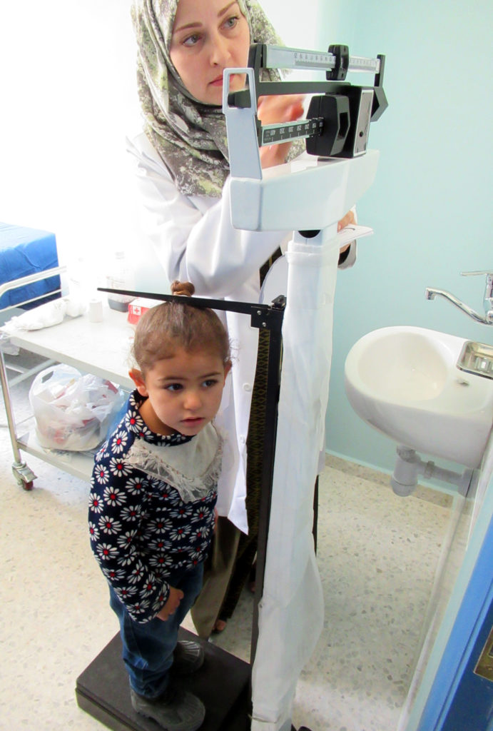 A youngster in Beit Lahia, Gaza is measured by a nurse