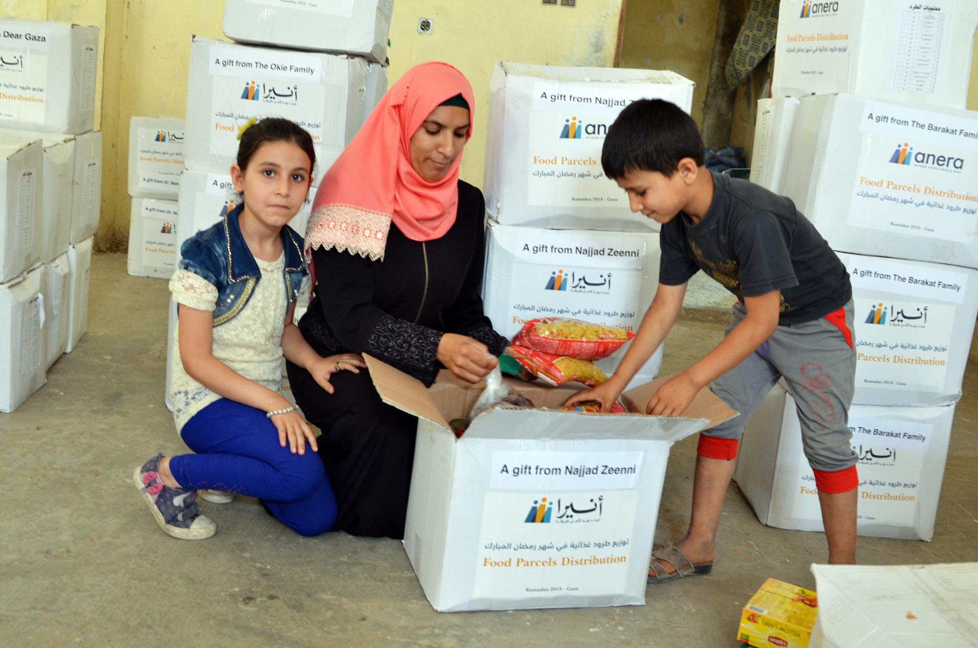 Fatima and her family receiving a food package.