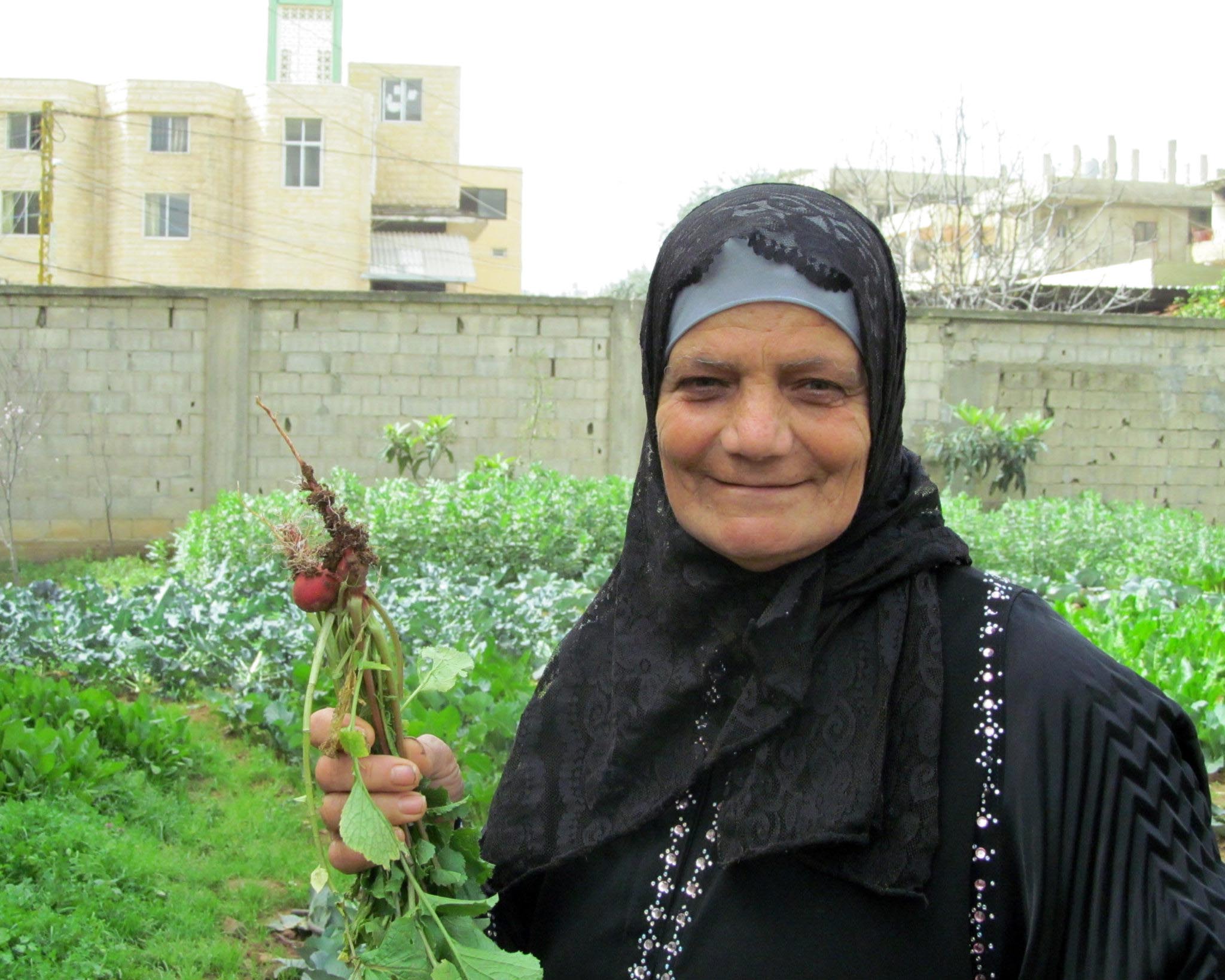 Nahr el Bared Garden Sobheya holds up her radishes that she carefully cultivated in the garden Anera installed in her Nahr El Bared community.