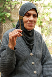 A Palestinian refugee holds up the key to their house in Palestine.