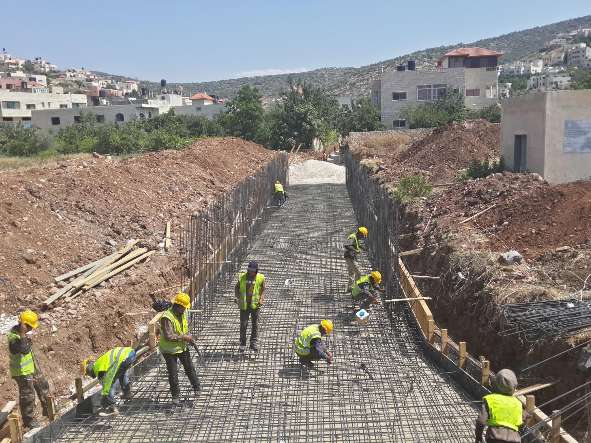 Workers construct the storm drainage system in Qabatiya