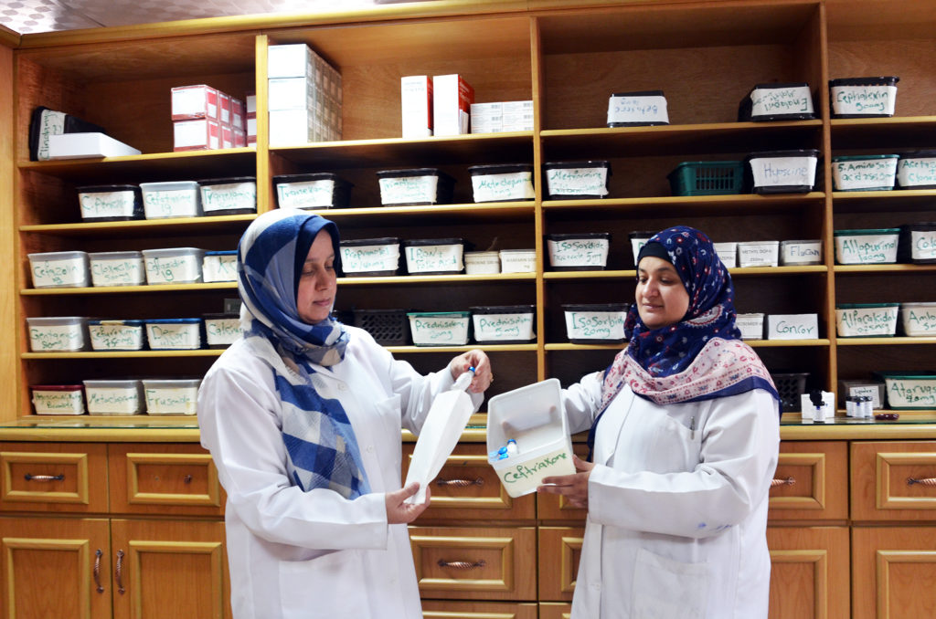 Two pharmacists sort out medicine in the central pharmacy of Al Shifa Hospital.