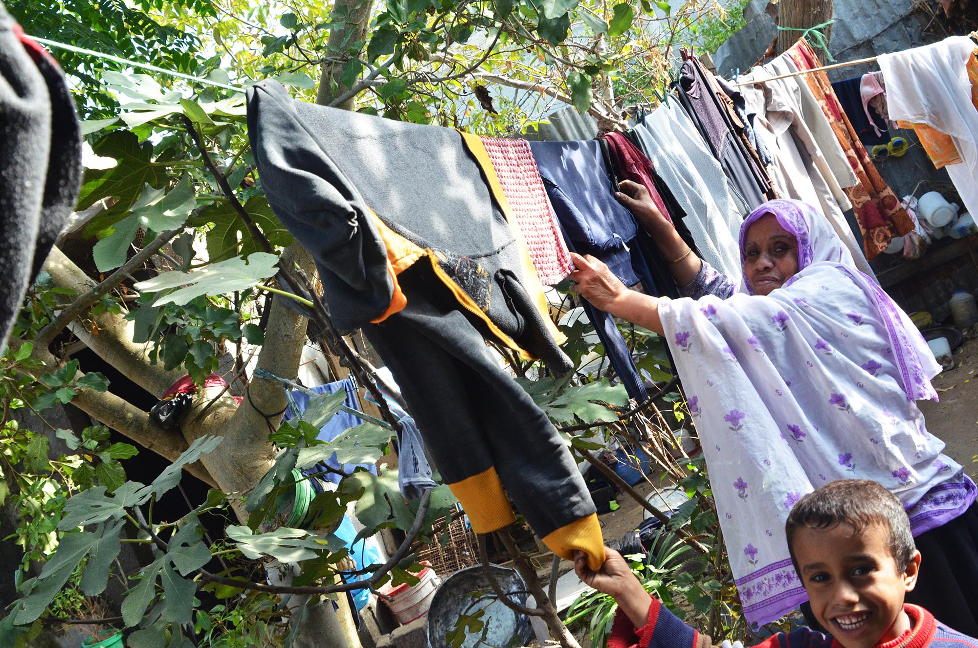 Amir and his mother hanging laundry.