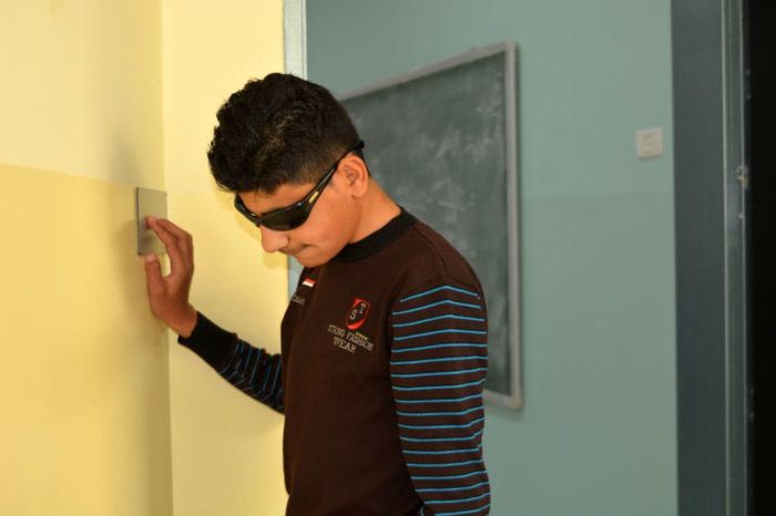 Omar uses the Braille signage to navigate the corridors of Jalqamous Boys’ School.