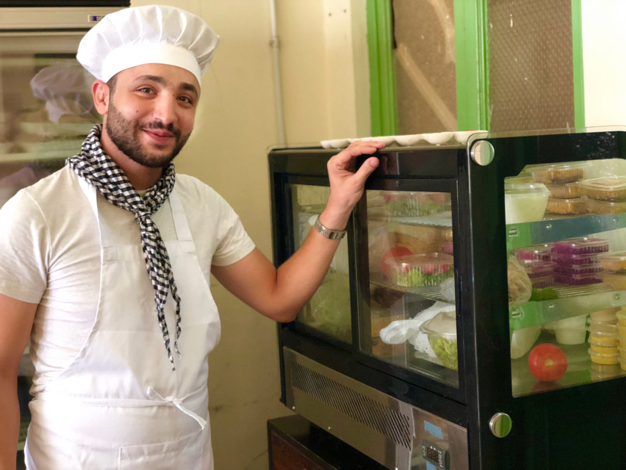 Chef Ahmad standing next to his dips and sauces fridge.