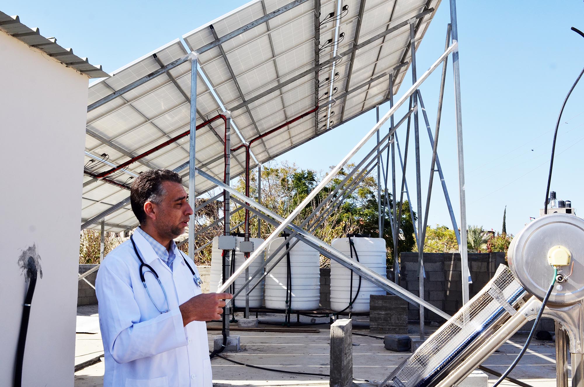Dr. Humeida shows us the solar panels up on the roof of the clinic in Beit Lahia.