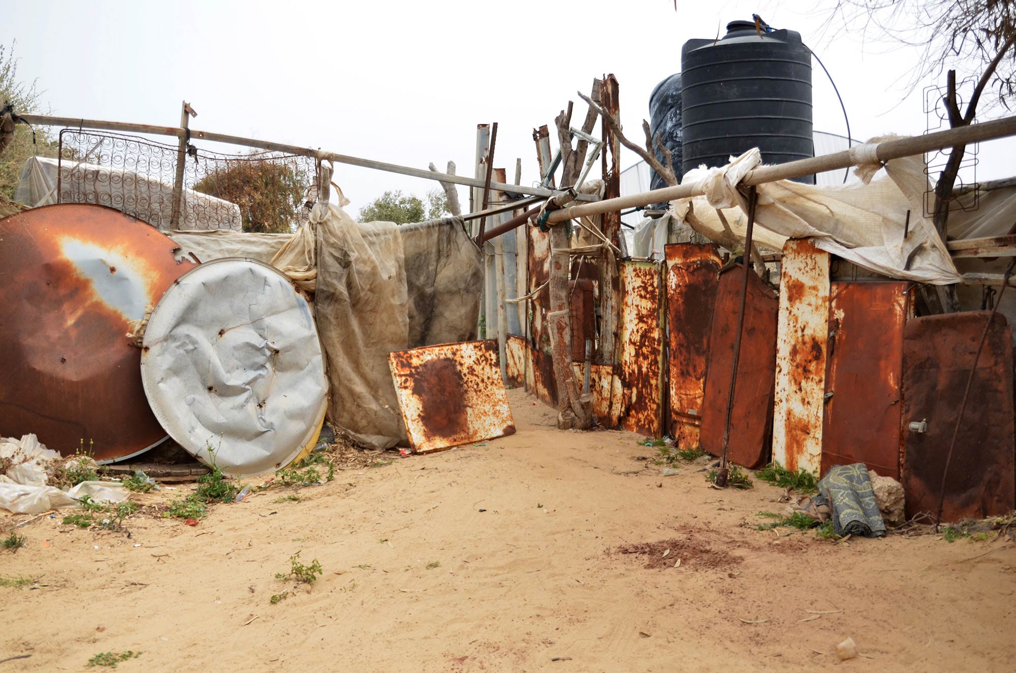 Amena and her mother live in this tented home, built with scrap metal and other found materials.