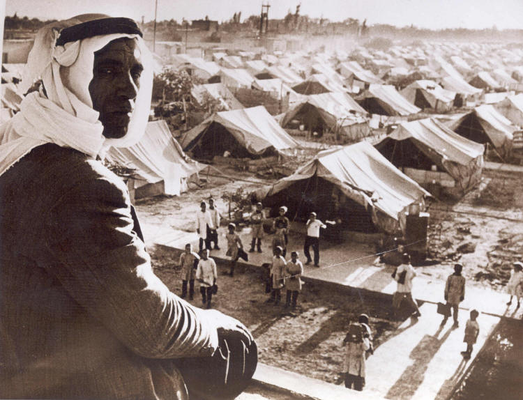 A Palestinian man watches over a school in a refugee camp, 1948.