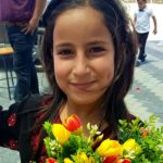 A Ni'lin schoolgirl with flower bouquet