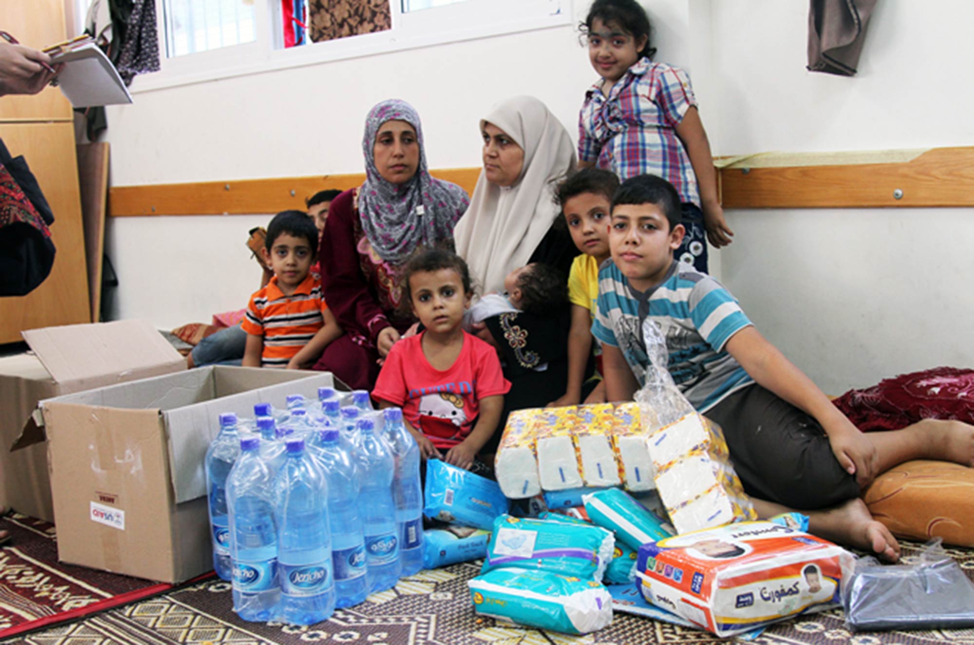 Um Khalil Skaik and her family, displaced and living in a UN school shelter in Gaza following the 2014 conflict.