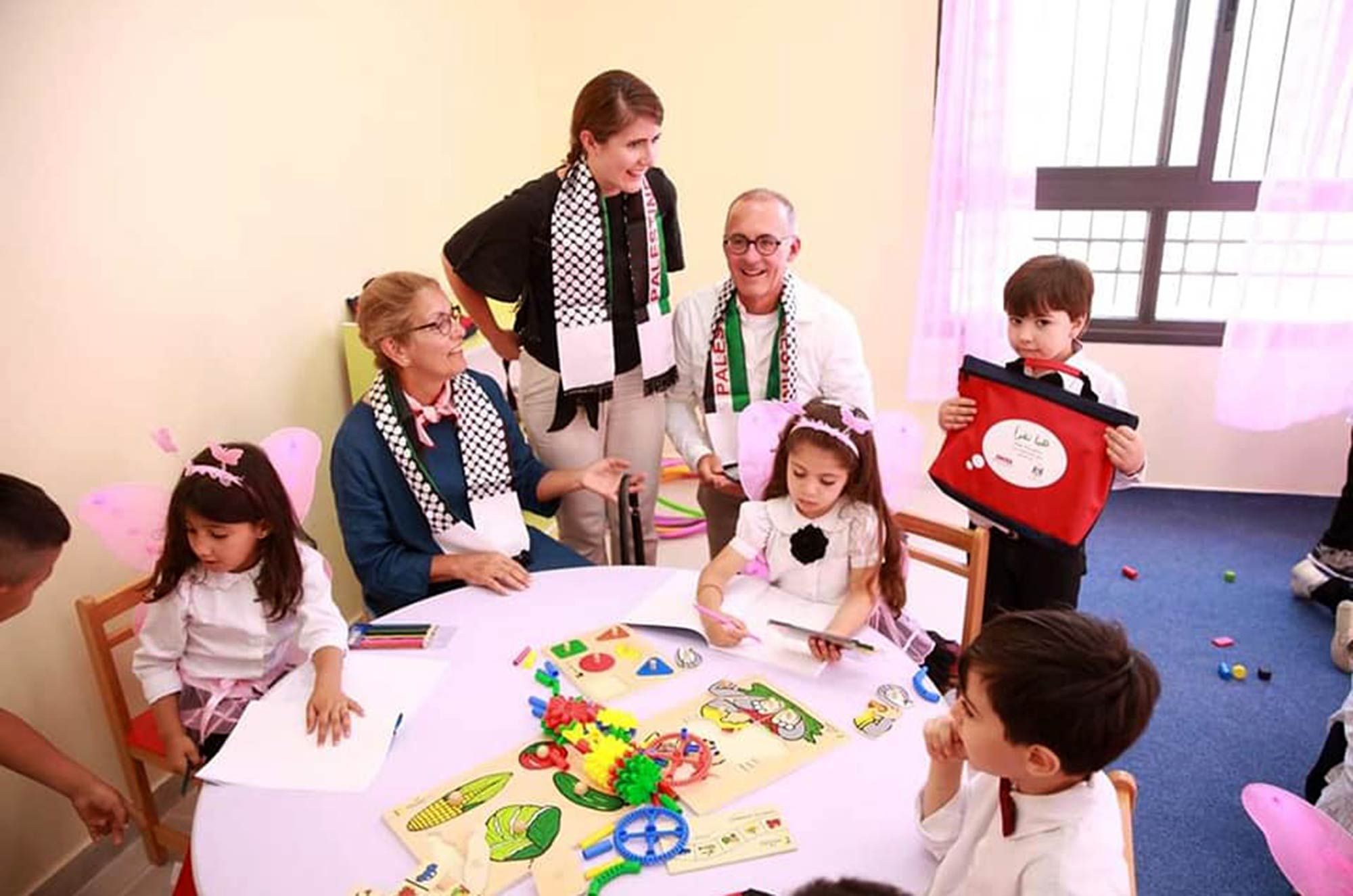 The Stengel family with school children at an arts and crafts table in the new Ni'lin preschool
