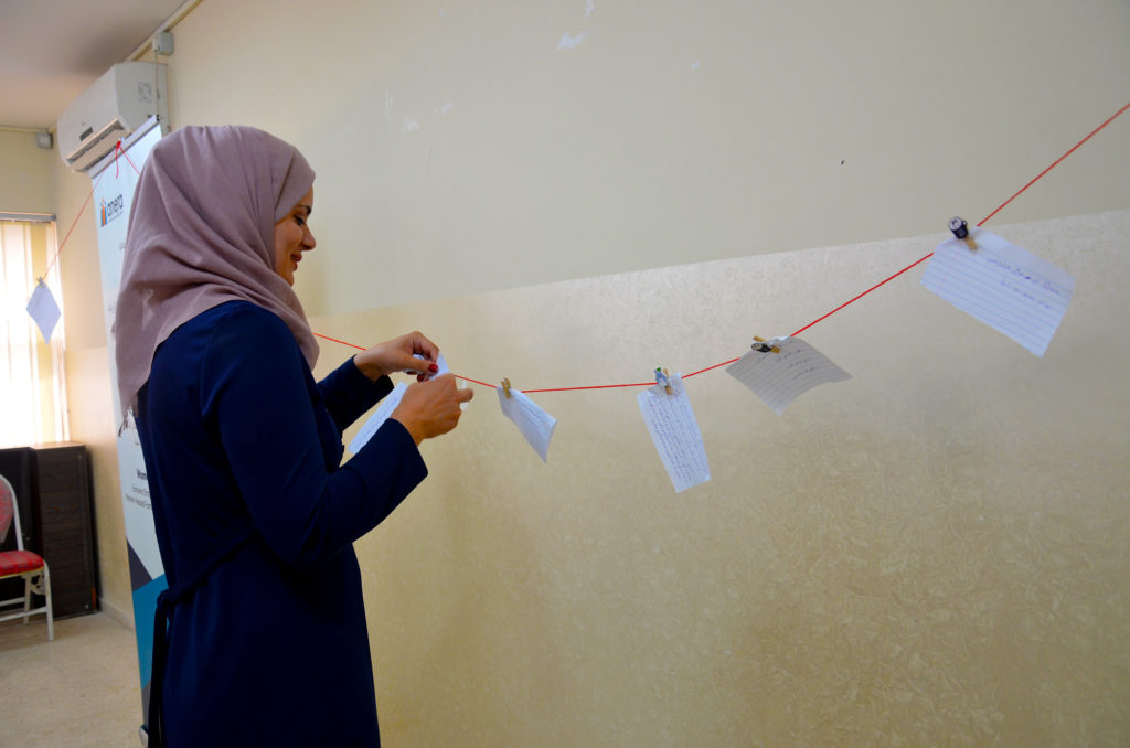 A participant in Anera's Woman Can program hang a note expressing her hopes for her project.