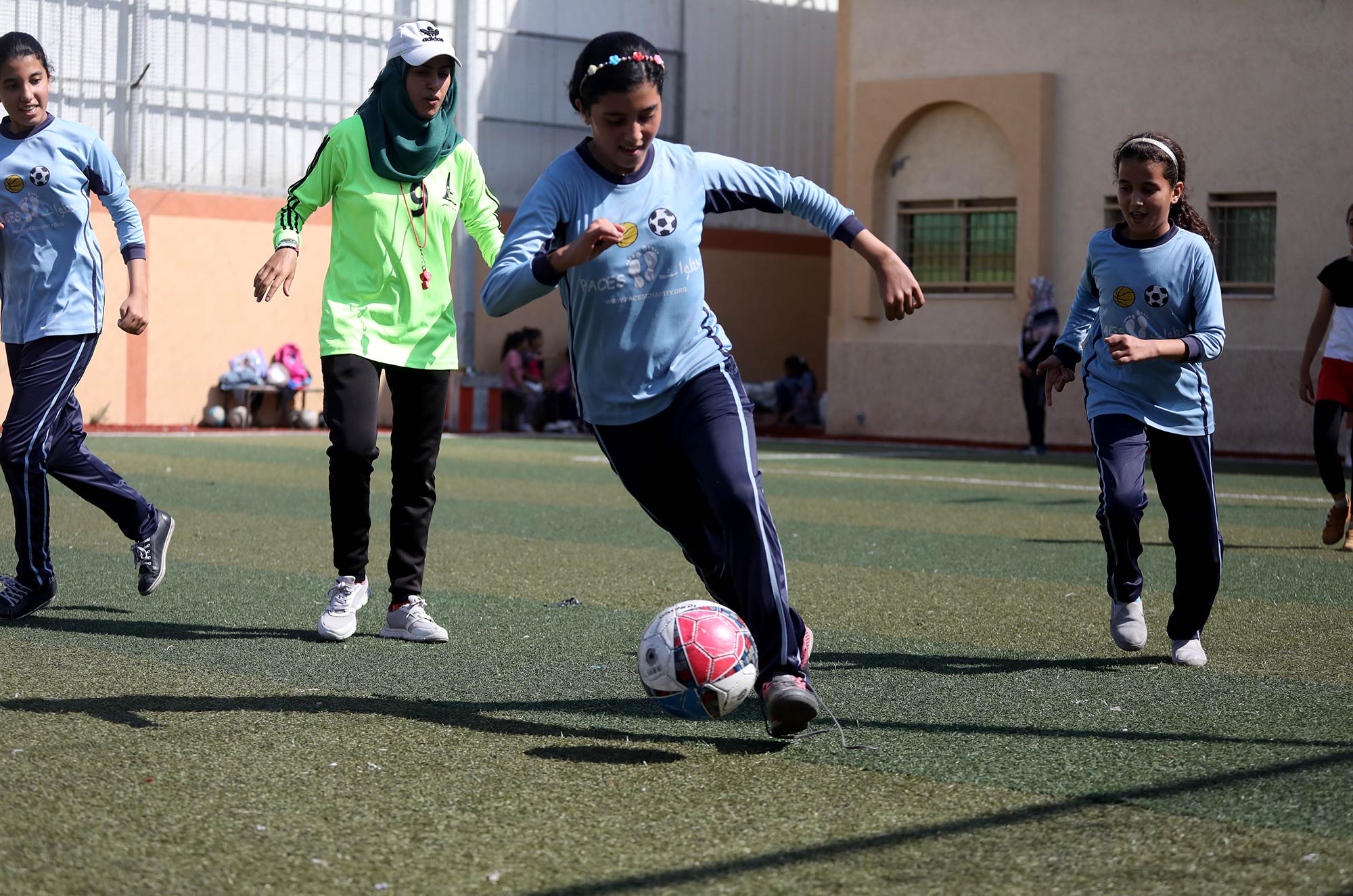A member of the girls sports team makes a run with the ball.