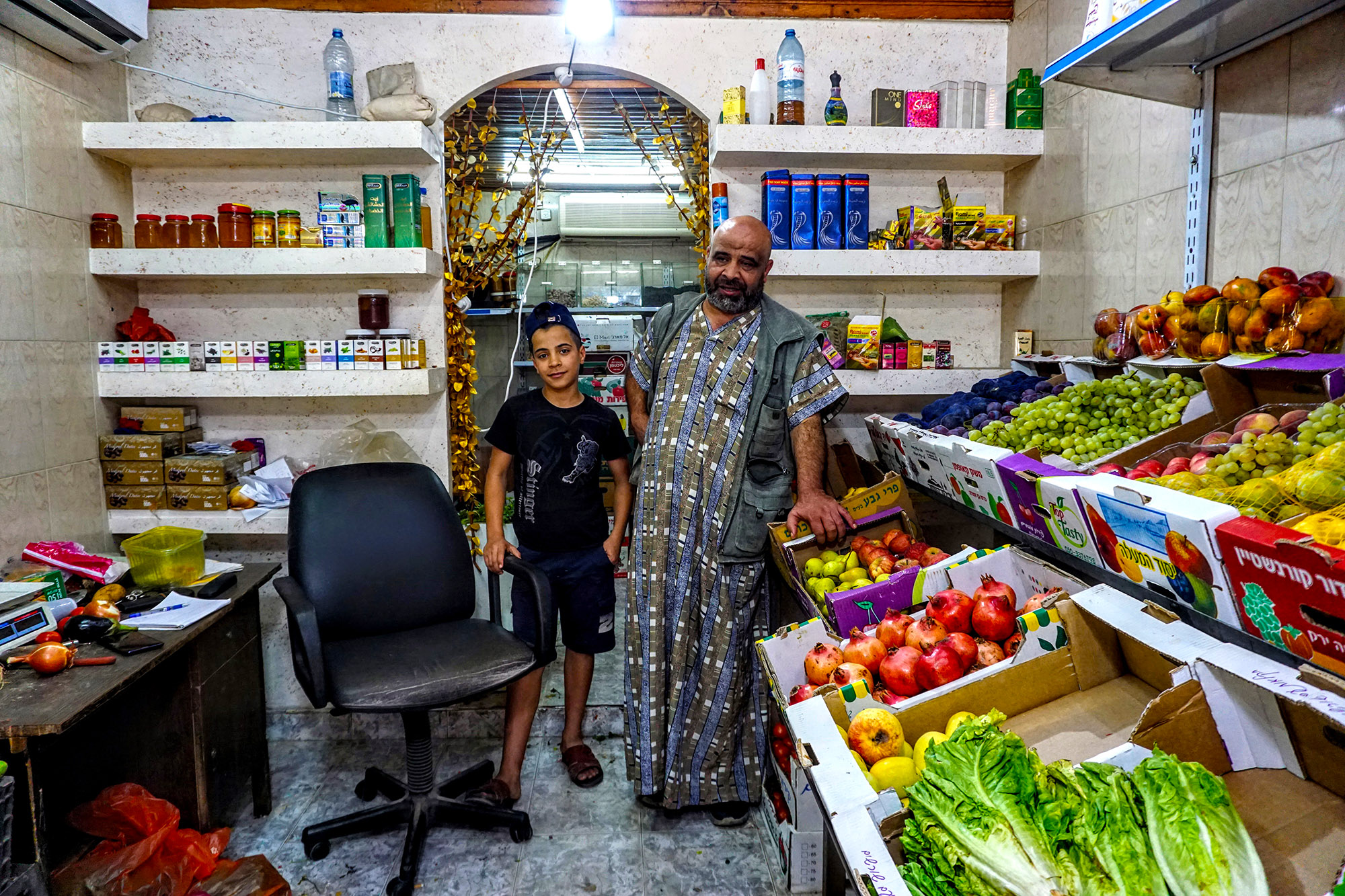 Raed and his son Ghaith sell fruits and spices in the Balata market.
