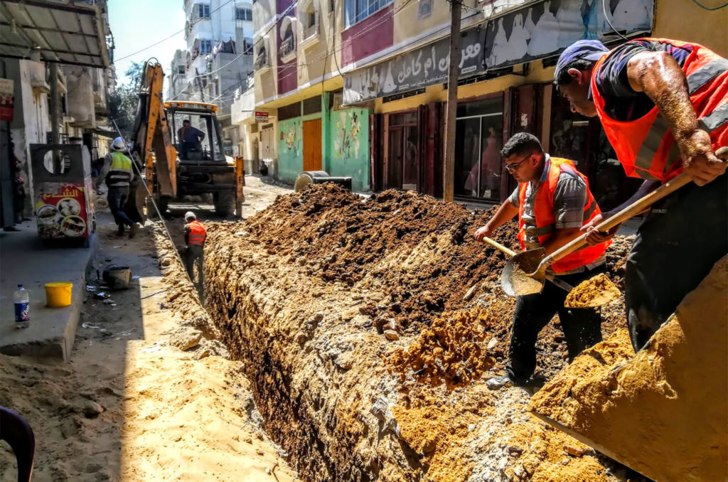 Workers dig deep trenches in the street in order to lay the new sewage lines.