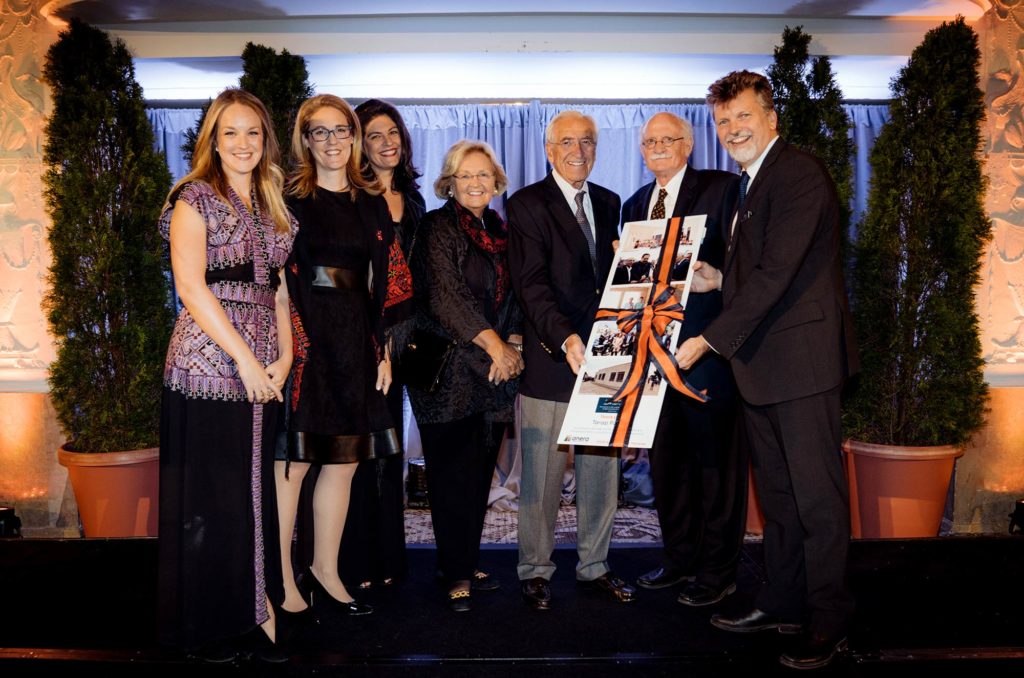 The Tarazi family accept a gift from Anera, presented by outgoing Board Chair David Nygaard, and President and CEO Sean Carroll.