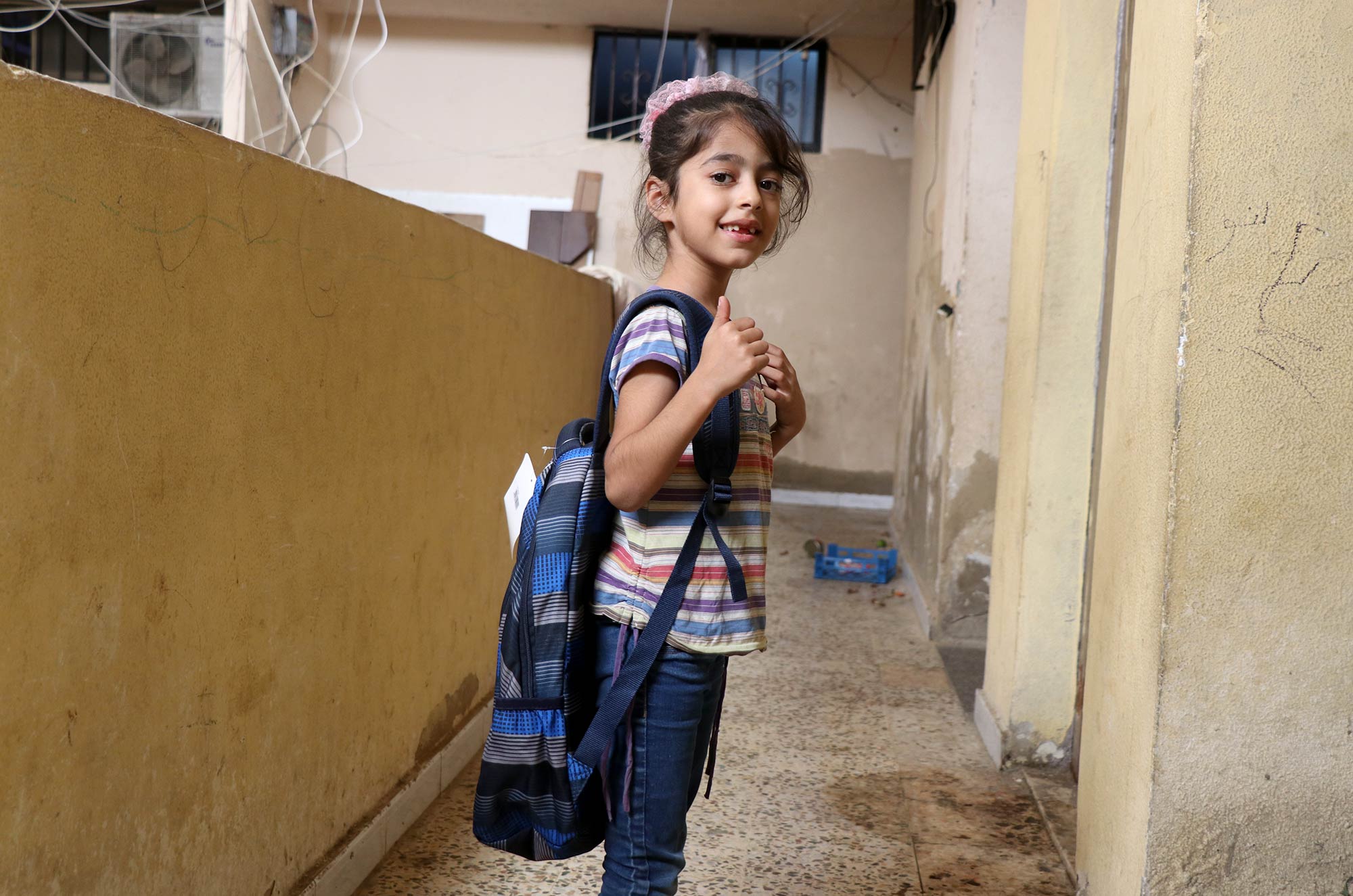 Anera, Lebanon, education, Burj-El-Barajneh, Beirut, school-bags A young student shows off her new school bag at Burj El Barajneh refugee camp, Beirut, Lebanon.