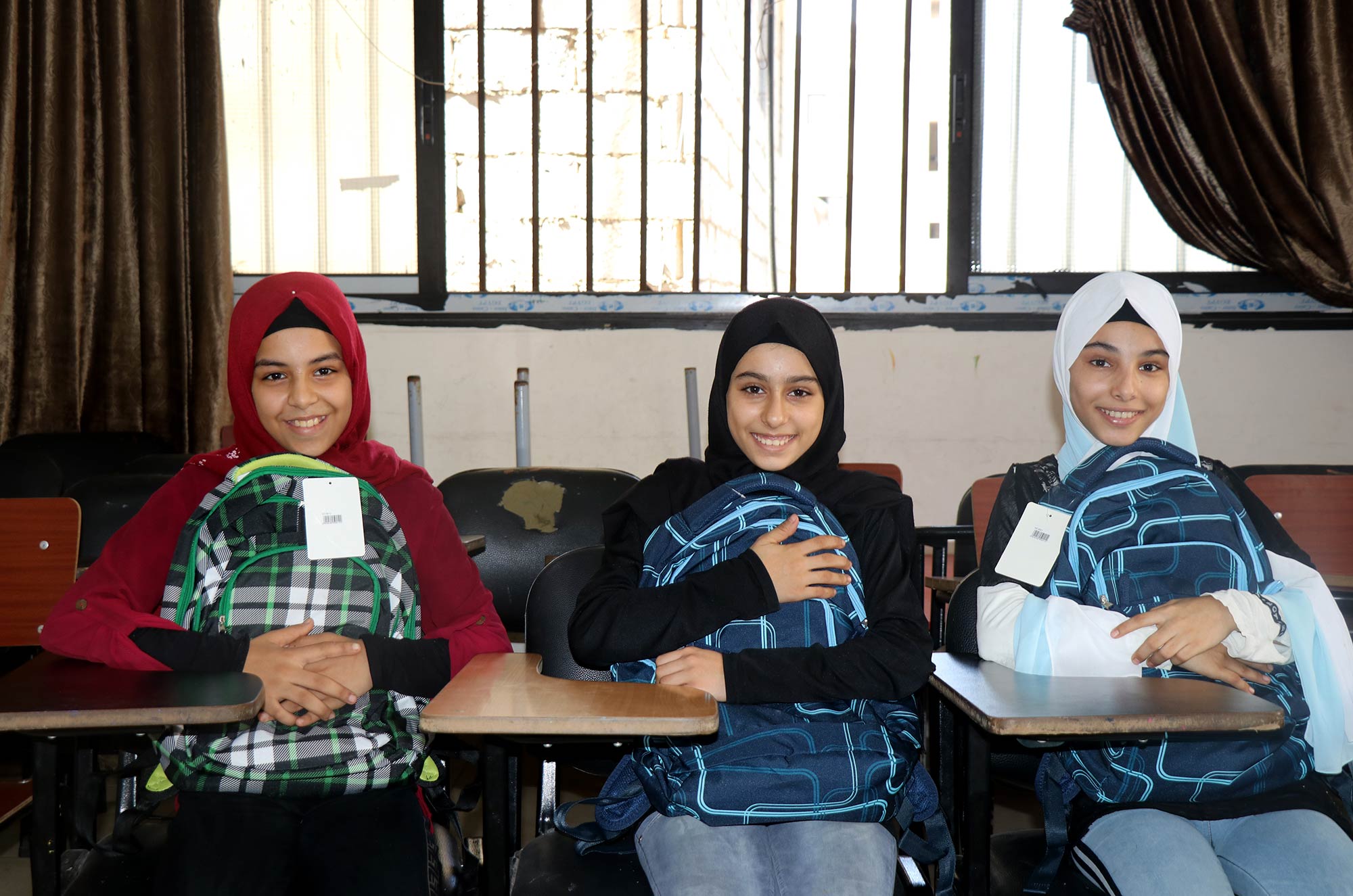 Anera, Lebanon, education, Burj-El-Barajneh, Beirut, school-bags, students Three students clutch their school bags.